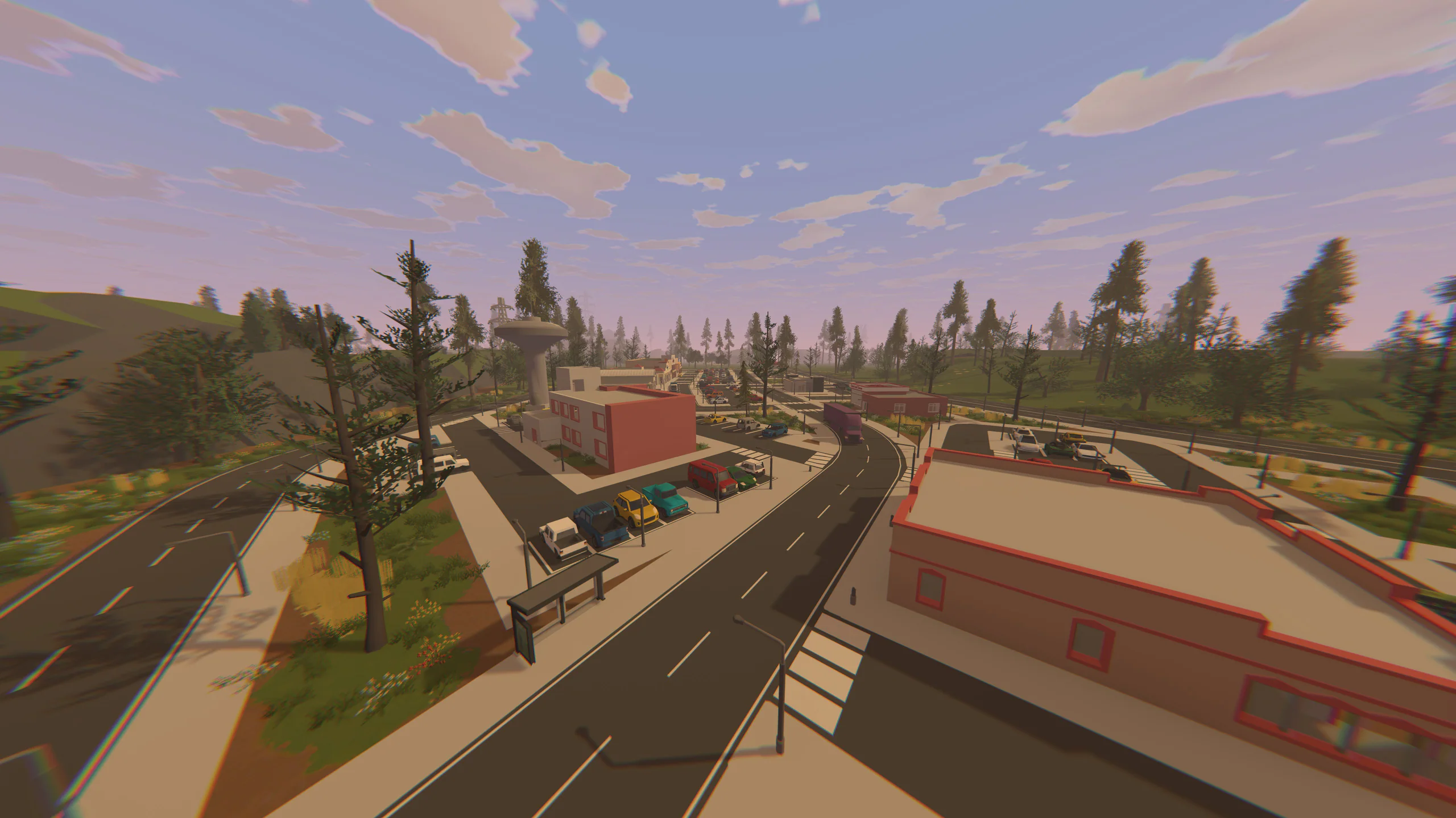 Daytime aerial view of a highway interchange cutting through a wooded town