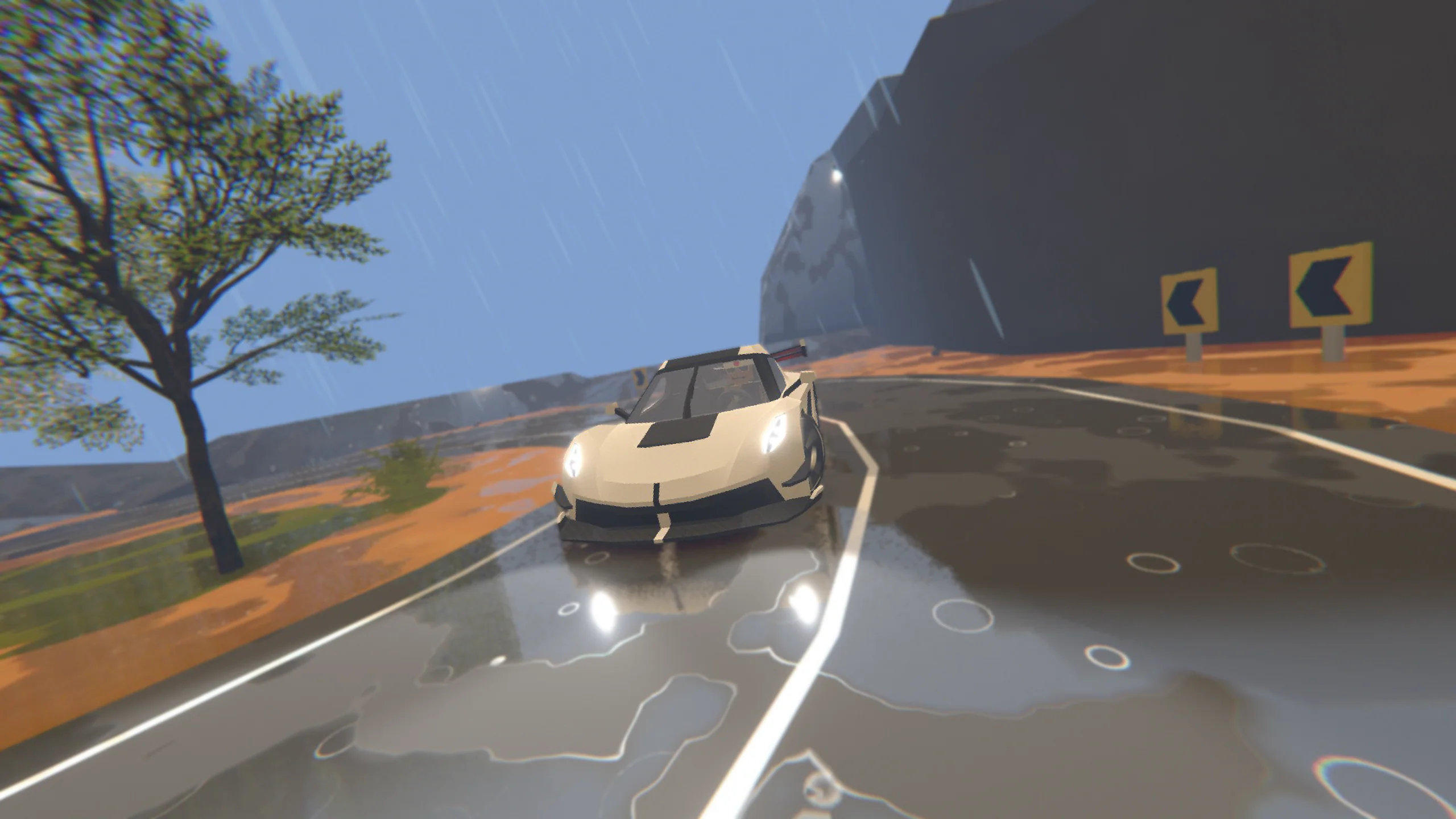Daytime coastal road hugging a cliffside, mountains and warning signs in view